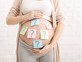 אישה בהריון סטיקרים על הבטן שמות ילדים (צילום: By Prostock-studio, shutterstock)