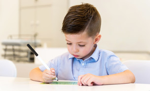 ילד כותב מכתב (צילום: Dobo Kristian, Shutterstock)