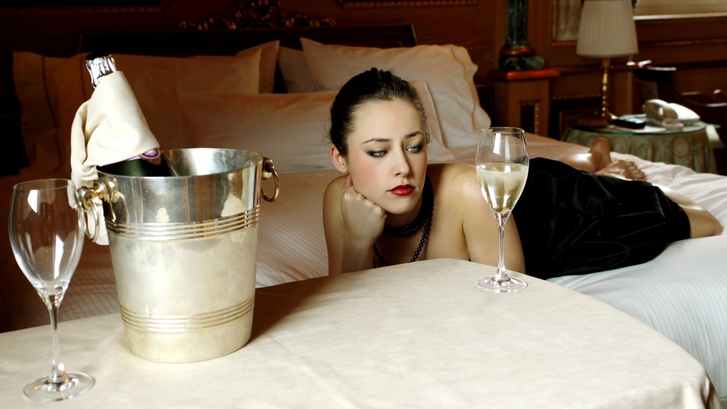 אישה יפה מחכה במיטה עם שמפניה (אילוסטרציה: shutterstock)