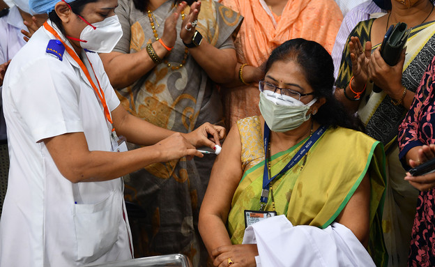 עובדת מערכת הבריאות בהודו מקבלת חיסון קורונה בבית חולים במומבאי (צילום: cnn)