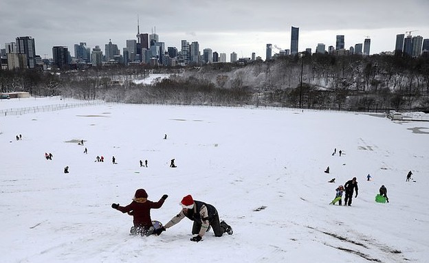 תושבי האזור משתעשעים בשלג שנערם בשטח המחנה (צילום: רויטרס)
