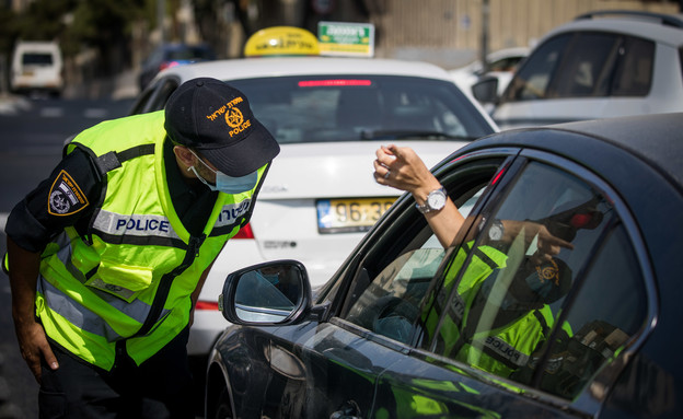 שוטר בודק כלי רכב במחסום זמני בירושלים בזמן הסגר, ספטמבר 2020 (צילום: יונתן סינדל, פלאש/90 )