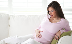 אישה בהריון על הספה- המדריך להריונית הנודניקית (צילום: istockphoto)