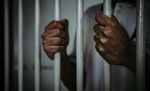 אדם שחור בכלא (צילום:  kittirat roekburi, shutterstock)