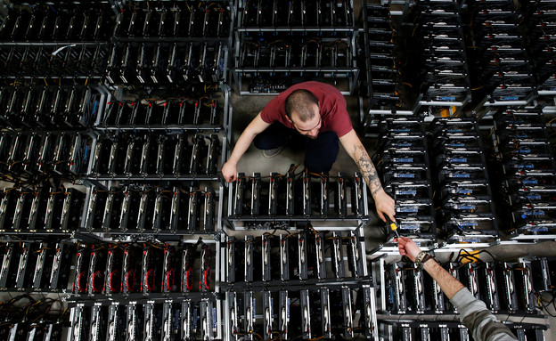 עובד במפעל כריית הביטקוין של החברה הסינית ביטמיין, איטליה (צילום: רויטרס)