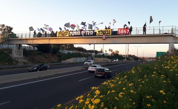 מחאה בגשר סמוך למחלף בית ינאי (צילום: הדגלים השחורים)