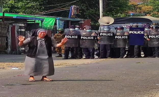 נזירה עומדת בין חיילים למפגינים במיאנמר