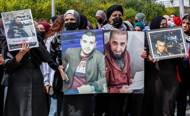 מפגינות באום אל פחם מחזיקות תמונות של נרצחים (צילום: AHMAD GHARABLI, AFP)