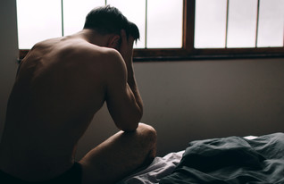 גבר יושב על המיטה בדיכאון (צילום: Estrada Anton, Shutterstock)