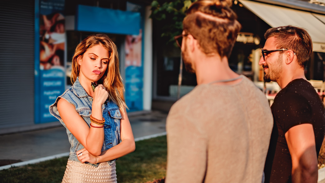 אישה מחייכת בוחרת בין שני גברים