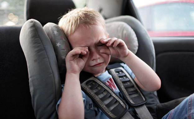 ילד בוכה במכונית (צילום: shutterstock By Maria Symchych)