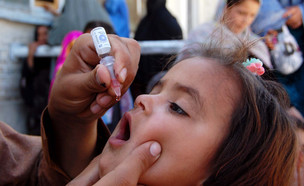 Health worker administrates polio-vaccine drops to (צילום: Asianet-Pakistan, Shutterstock)