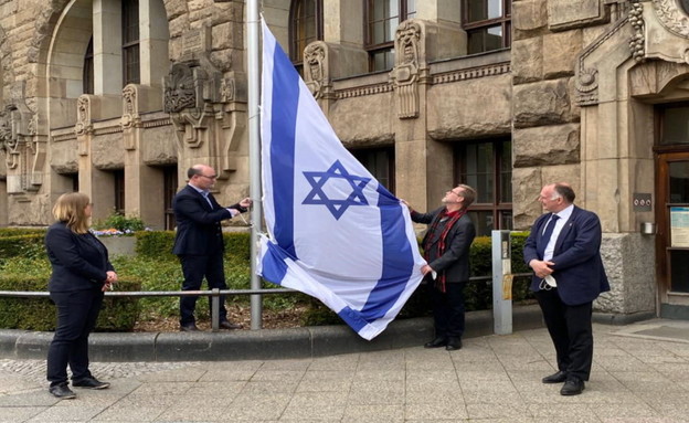 תושבים בגרמניה מניפים דגל ישראל לאות תמיכה