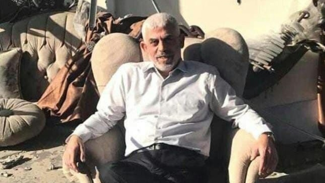 מנהיג חמאס ברצועת עזה, יחיא סינוואר, על כורסה במשרד ההרוס