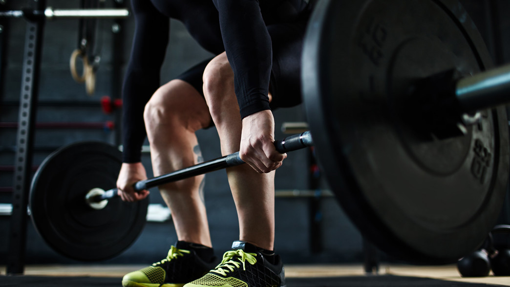 איש שרירי מרים משקולות בחדר כושר איש שרירי מרים משקולות בחדר כושר