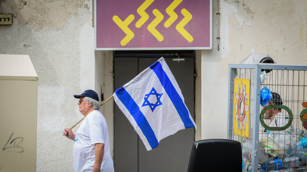 מפגין עם דגל ישראל מול משרדי גלגל"צ