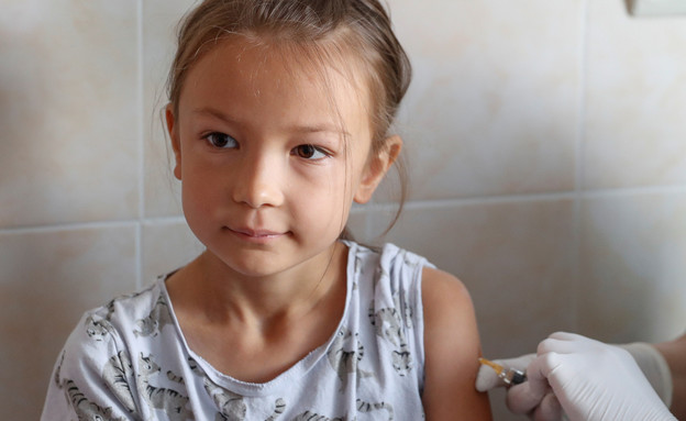 ילדה מקבלת חיסון במרפאה בקייב, אוקראינה (צילום: רויטרס)