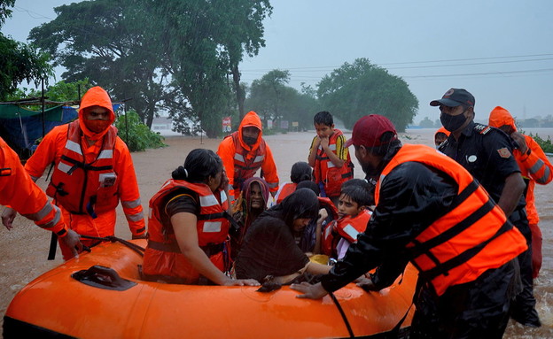 צוותי חילוץ מחלצים תושבים מקולהפור שבהודו למקום בטוח אחרי ההצפות (צילום: רויטרס)