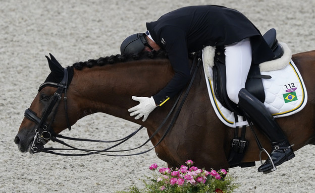 הרוכב הברזילאי מחבק את הסוס באולימפיאדה (צילום: reuters)