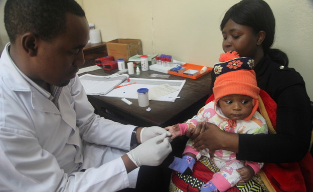 רופא בודק ילד למחלת המלריה בטנזניה אפריקה (צילום: רויטרס)