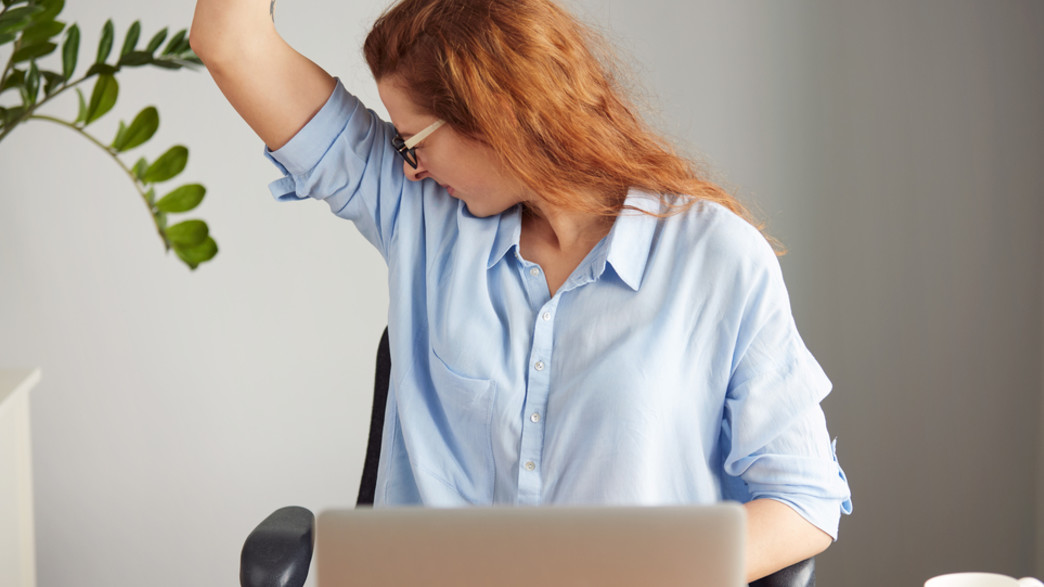אישה מזיעה במשרד (אילוסטרציה: Shutterstock)