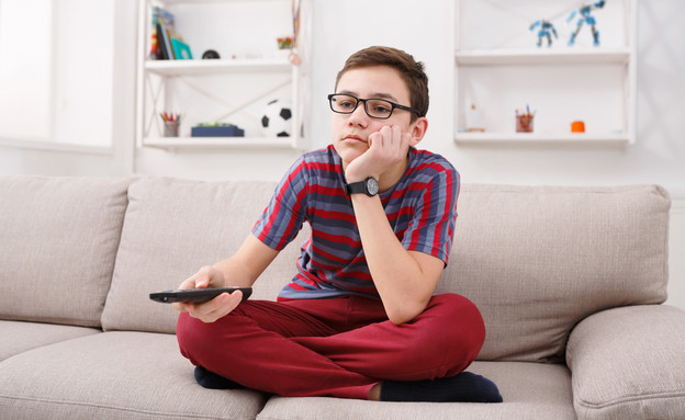 ילד צופה בטלוויזיה (צילום: shutterstock By Prostock-studio)