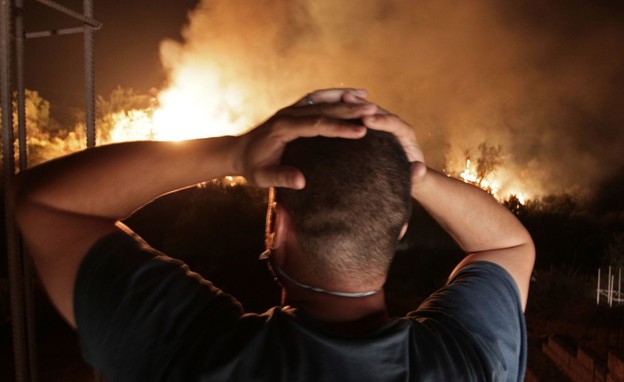 אדם צופה בשרפה גדולה באלג'יריה (צילום: AP, SKY NEWS)
