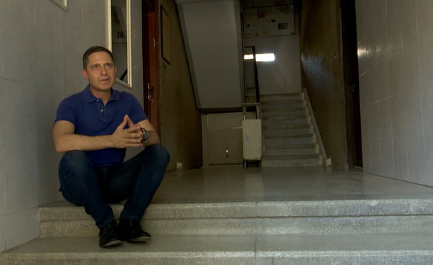  רוביק דנילוביץ' יושב בכניסה לבית ילדותו (צילום: חדשות 12)