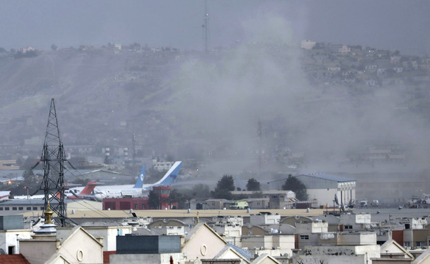 שאריות עשן שנותרו מהפיצוץ סמוך לשדה התעופה בקאבול  (צילום: AP)