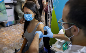 צעירה ישראלית מקבלת את מנסת החיסון השלישית (צילום: פלאש/90 )