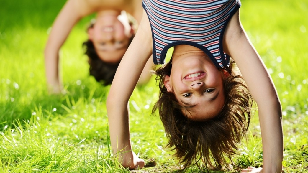 ילדים מחייכים עומדים על הידיים (צילום: Zurijeta, Shutterstock)