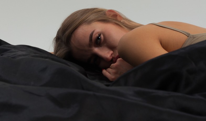 אישה שוכבת במיטה (אילוסטרציה: semen zhuravlev, unsplash)