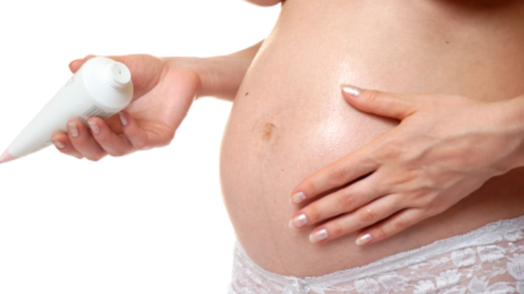 מורחת קרם על בטן הריונית- טיפוח בהריון