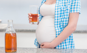 אישה בהיריון שותה כוס מיץ במטבח (אילוסטרציה: Ermolaev Alexander, shutterstock)