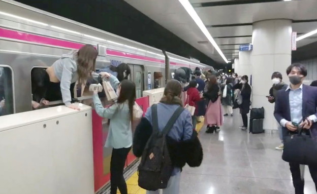 אנשים בורחים ברכבת בטוקיו אחרי שאדם מחופש לג'וקר ד (צילום: רויטרס)