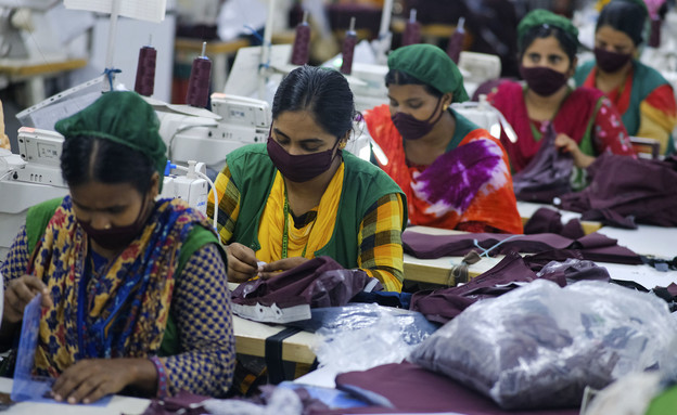 עובדים במפעל בגדים במזרח (צילום: AP)