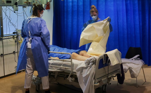 צוותים רפואיים מכינים שקית לעטוף את גופתו של אדם ש (צילום: reuters)