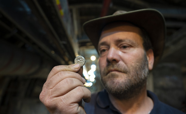 מנהל החפירה, ארי לוי, מחזיק את המטבע הנדיר (צילום: יניב ברמן, עיר דוד ורשות העתיקות)