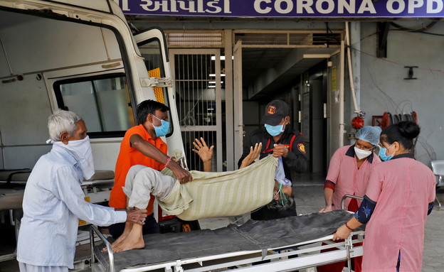 מטופל עם בעיית נשימה מובל לבית החולים, הודו (צילום: reuters)