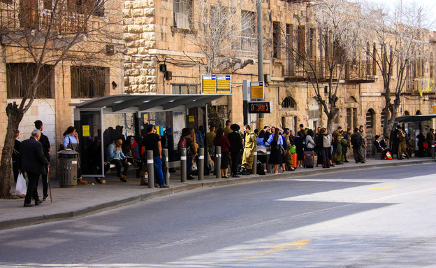 נוסעים בתחנת אוטובוס בדרך יפה, סמוך לתחנה המרכזתי בירושלים (צילום: shutterstock)
