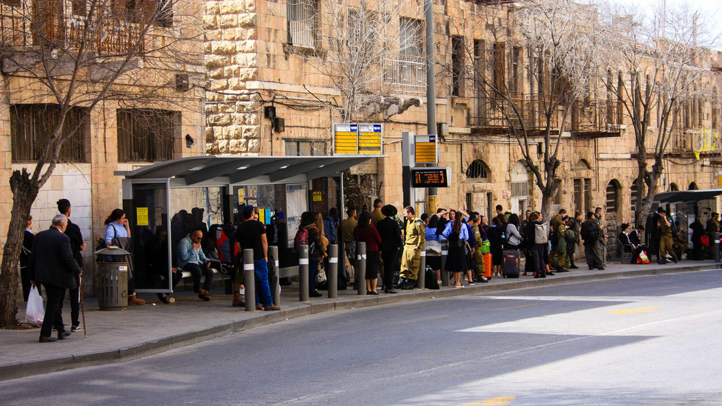 נוסעים בתחנת אוטובוס בדרך יפה, סמוך לתחנה המרכזתי בירושלים (צילום: shutterstock)