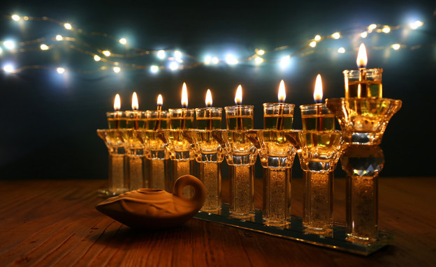 נרות חנוכה דולקים בחנוכיה (צילום: tomertu, shutterstock)