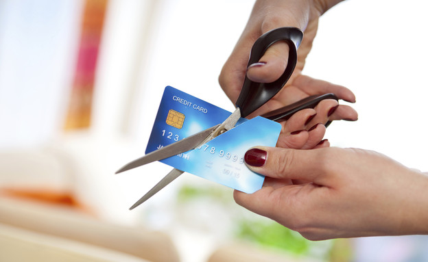 אדם גוזר במספריים כרטיס אשראי (צילום: אימג'בנק / Thinkstock)