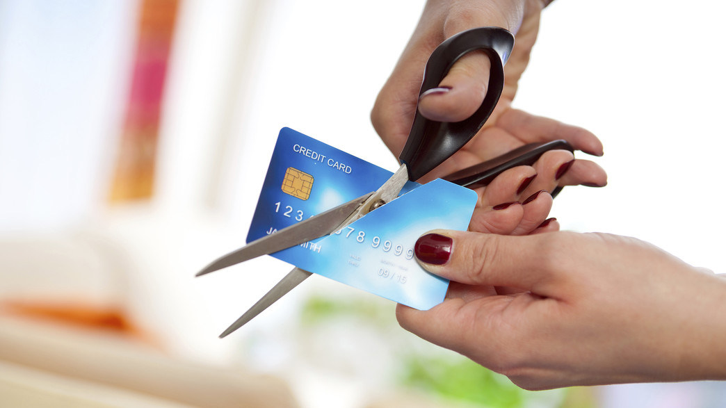 אדם גוזר במספריים כרטיס אשראי אדם גוזר במספריים כרטיס אשראי