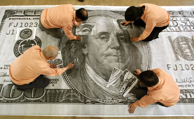 יפנים בודקים שטר מוגדל של 100 דולר (צילום: KAZUHIRO NOGI/AFP, Getty Images)