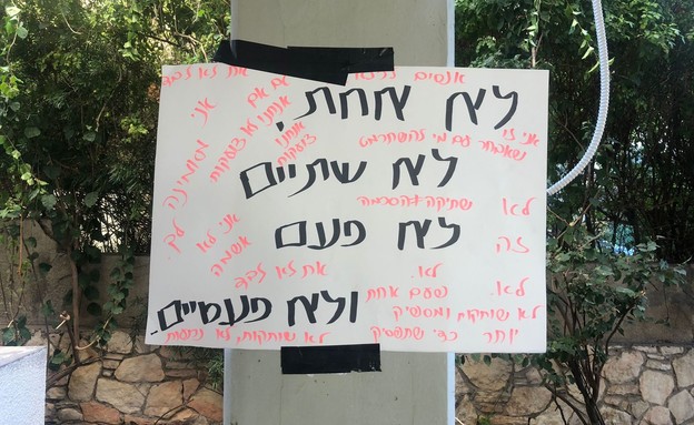 השלטים שנתלו מתחת לביתו של החשוד (צילום: פרטי)