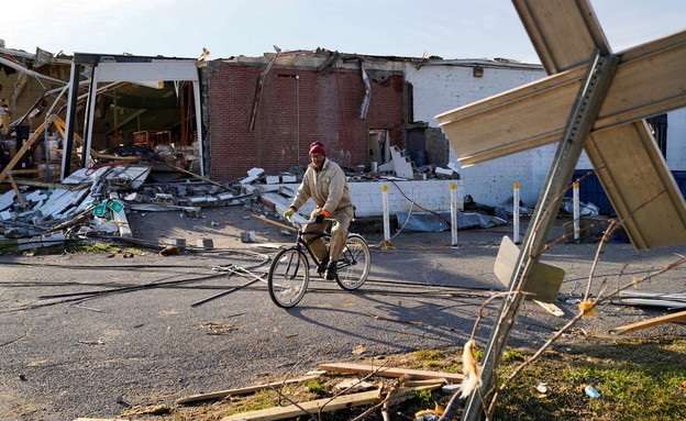 A man rides his bicycle after a tornado hit Mayfield, Kentucky (Photo: Reuters)