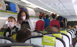 נוסעים בטיסה עם מסיכה (צילום: mariyaermolaeva, shutterstock)