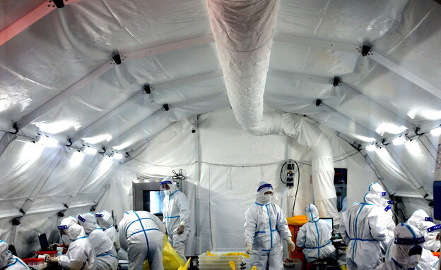 עובדים בתוך מעבדה מאולתרת שהוקמה בעקבות התפרצות הקורונה בשיאן (צילום: רויטרס)
