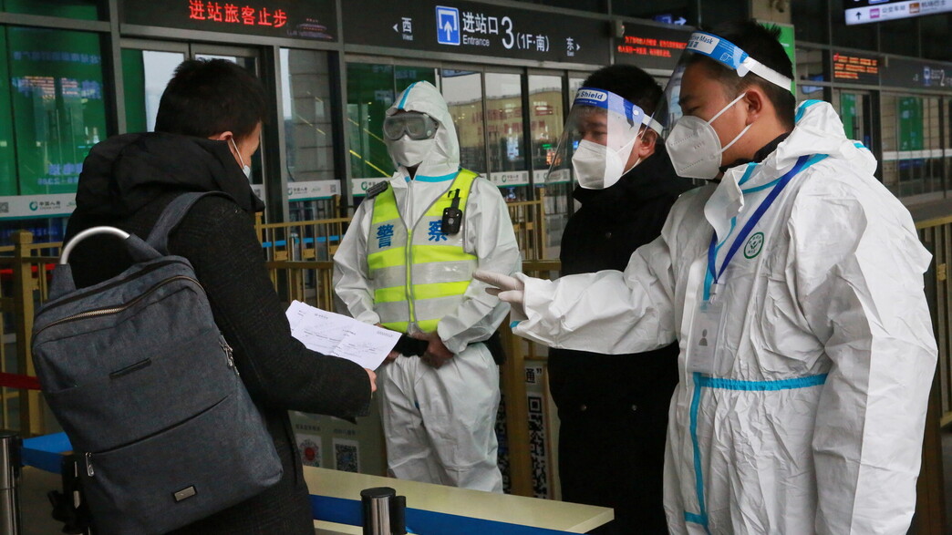 אנשי הצוות בודקים את המסמכים של נוסע בכניסה לתחנת רכבת בשיאן בסין  (צילום: רויטרס)